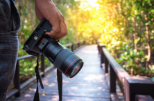 Camera in hand with golden light at the beginning of a walkway