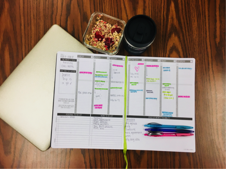 An organized, color coded planner with granola and coffee beside it with a note pad