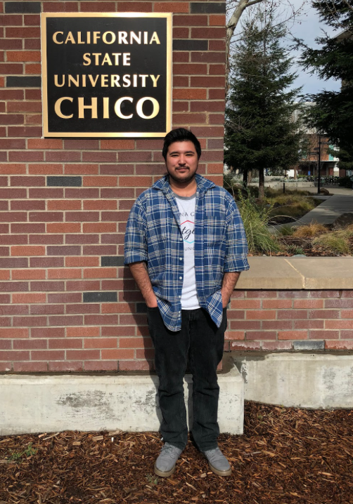 Jae Siqueiros standing in front of a Chico State sign in 2018